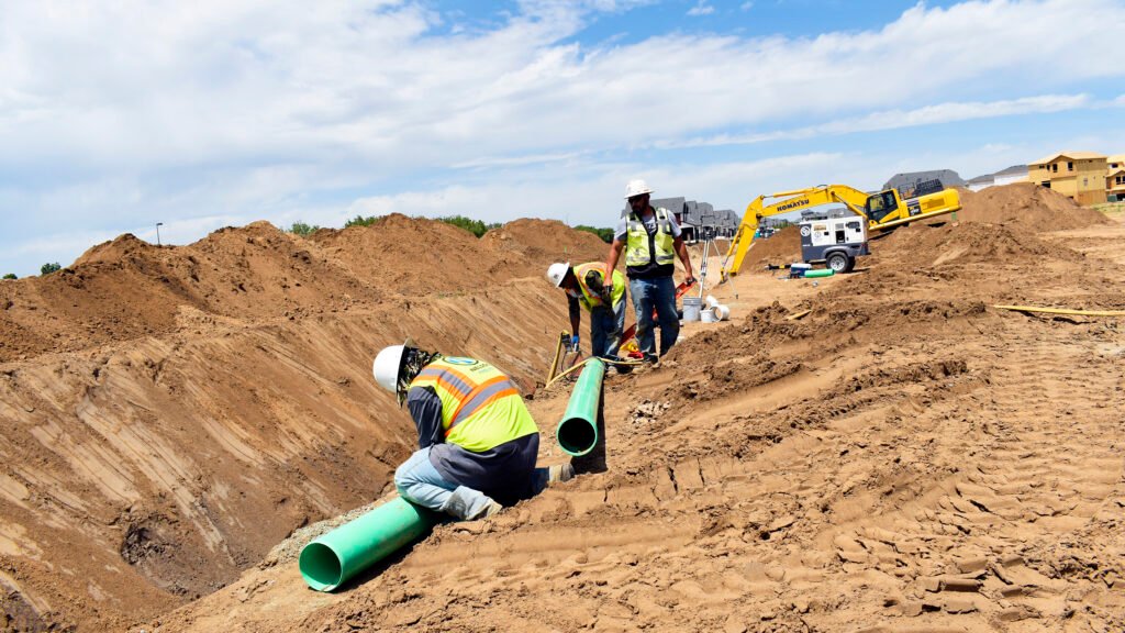 Nelson Pipeline employees laying pipe in a trench