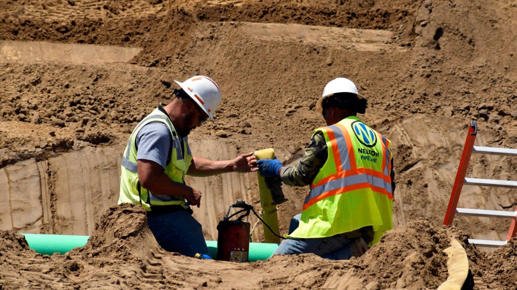 Nelson Pipeline employees working on a pipe on a job site